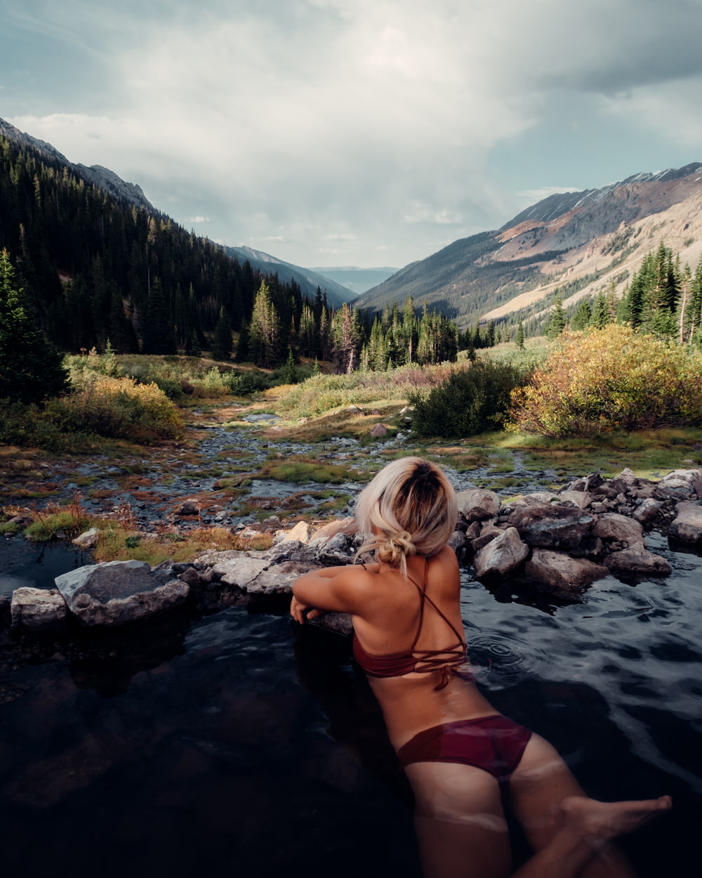 donna in bikini nero sul fiume durante il giorno