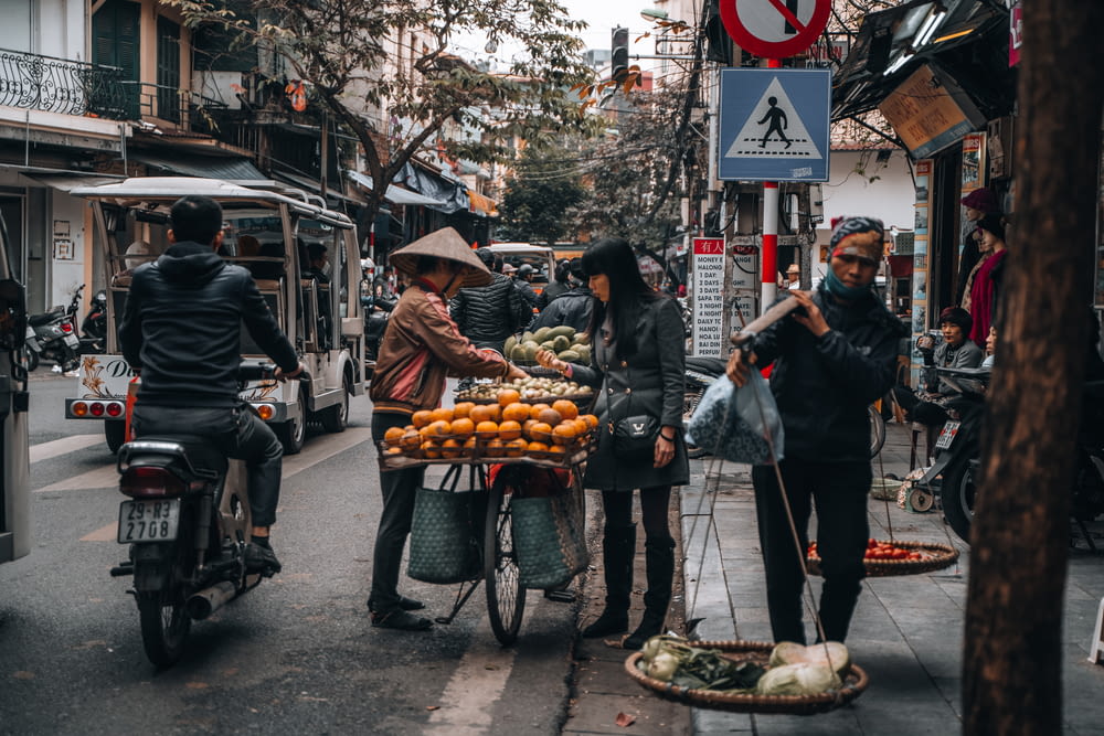 man in black jacket standing near food cart during daytime