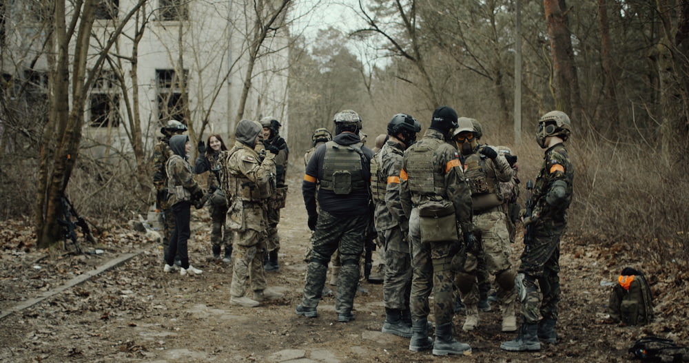 grupo de soldados em uniforme de camuflagem em pé no chão durante o dia