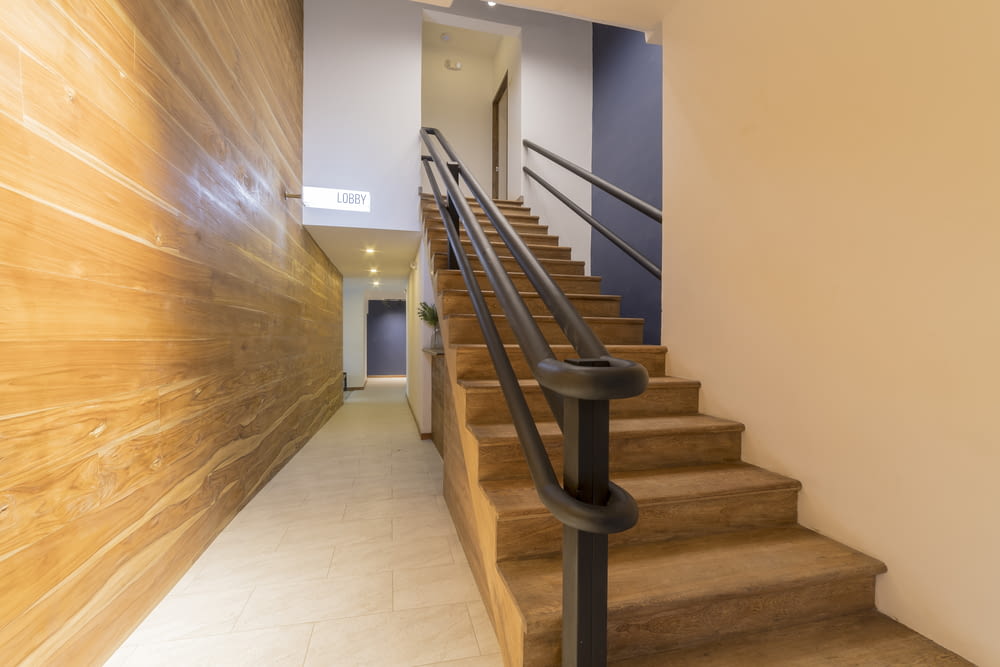 brown wooden staircase with stainless steel railings