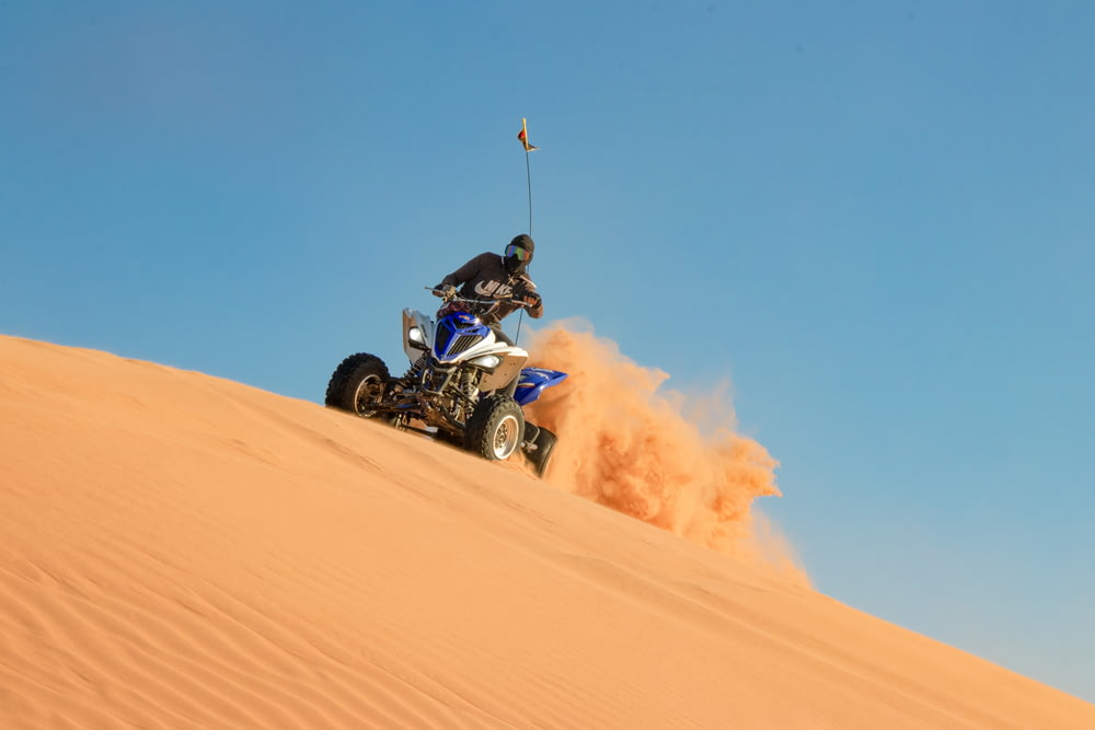 man riding on blue and black sports bike on desert during daytime