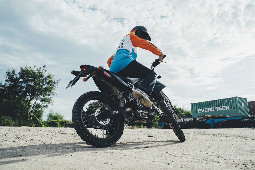 une personne conduisant une moto hors route sur un chemin de terre