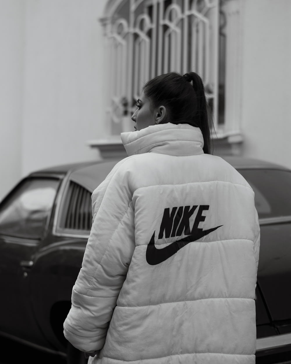 woman in white and black adidas hoodie standing near black car
