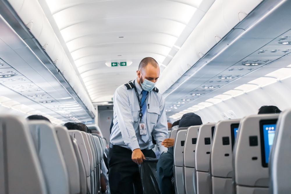 homem na camisa social azul de pé no avião