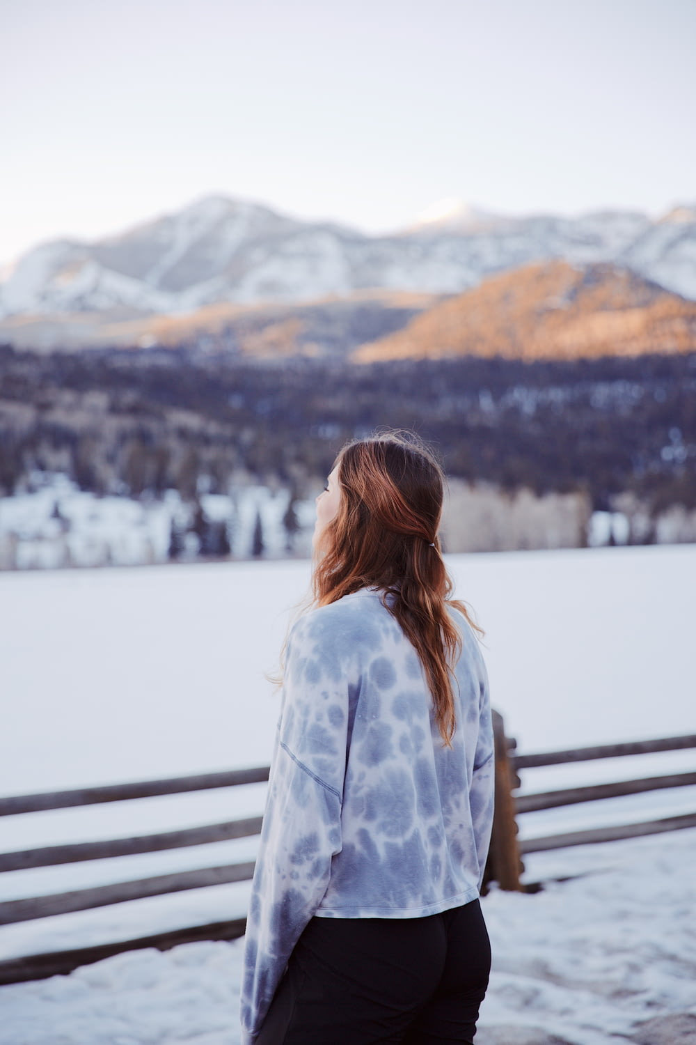 a woman standing in front of a snow covered mountain