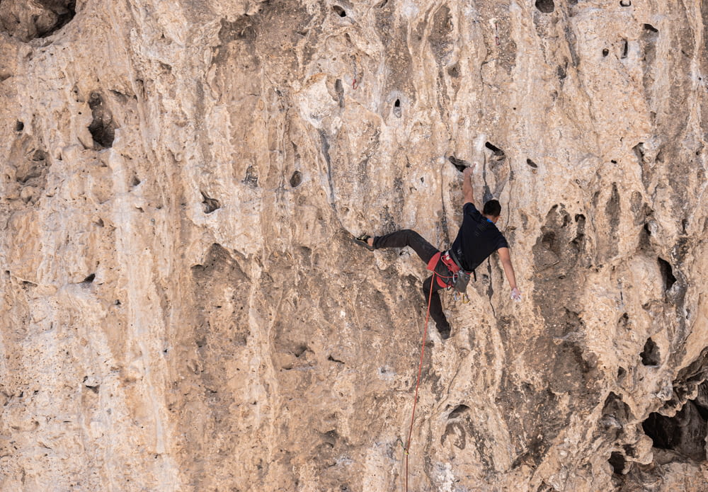 2 person climbing on brown rock formation during daytime