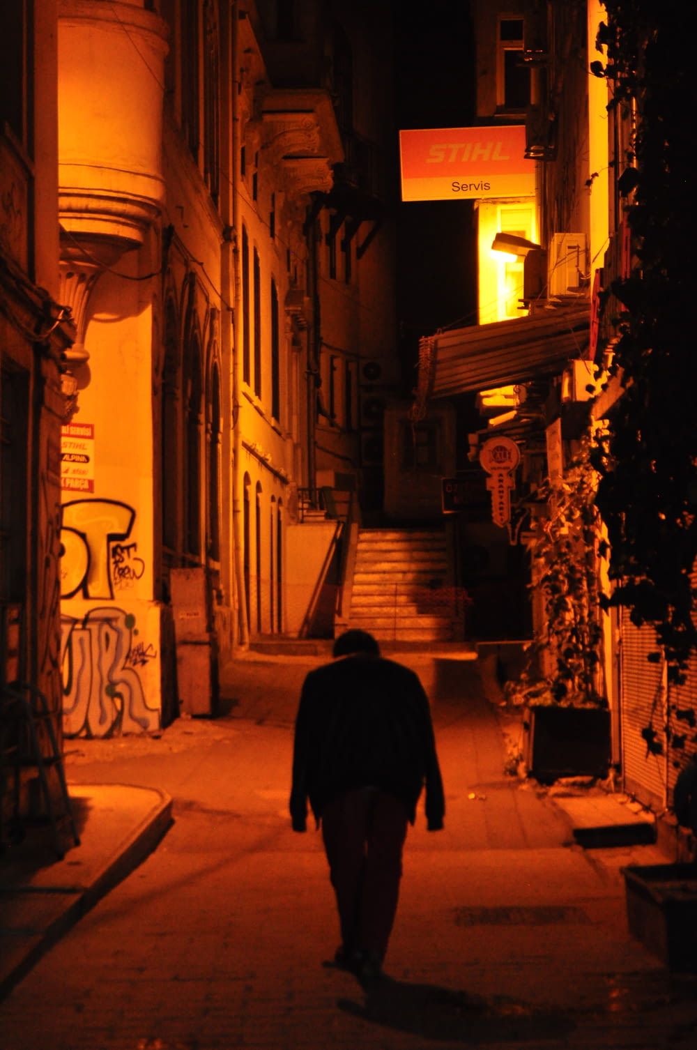 검은 코트를 입은 남자가 밤에 거리를 걷고 있다