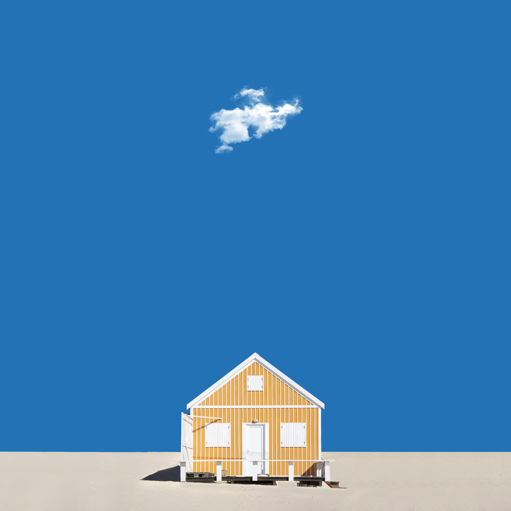 Casa de madera blanca y marrón bajo el cielo azul durante el día