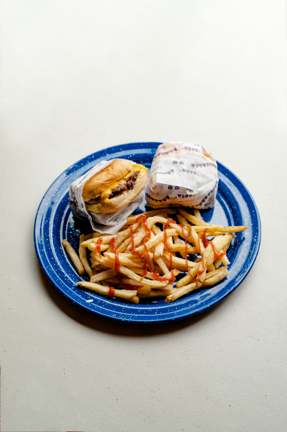 burger and fries on blue and white ceramic plate