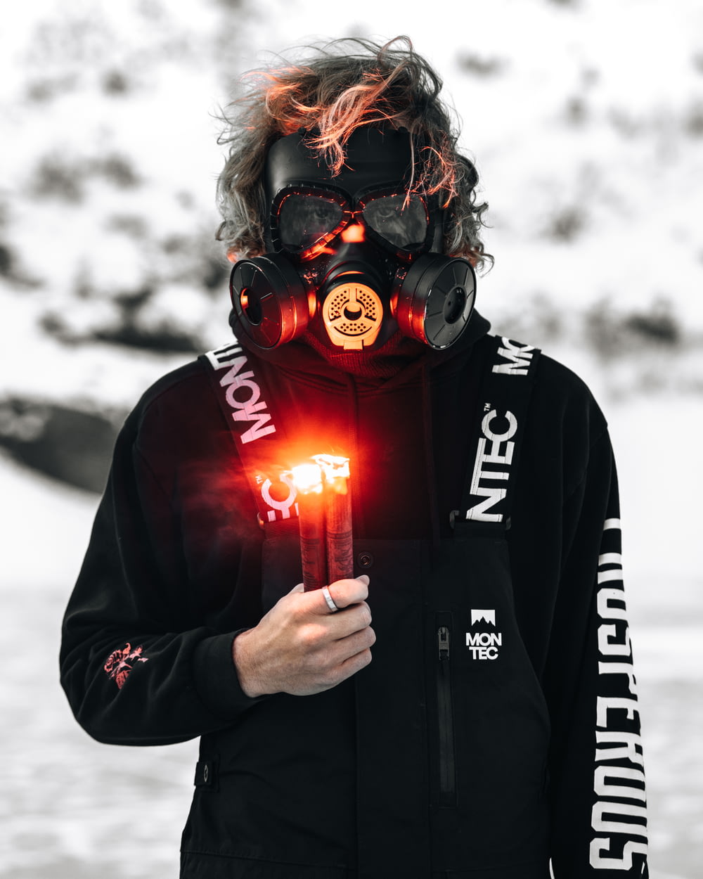 person in black and red hoodie wearing gas mask