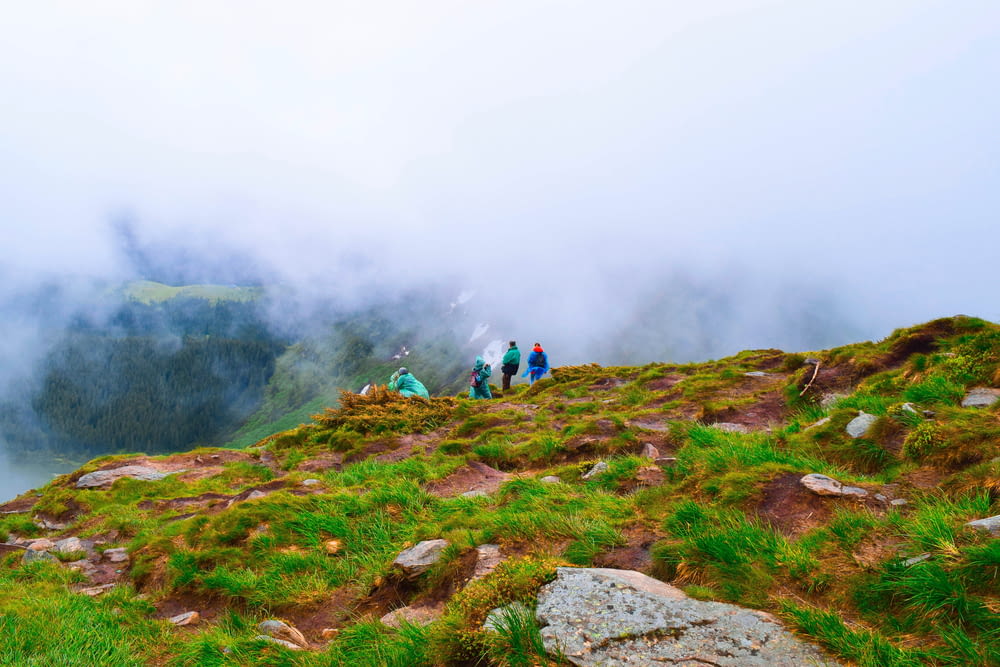 people hiking on mountain during foggy day