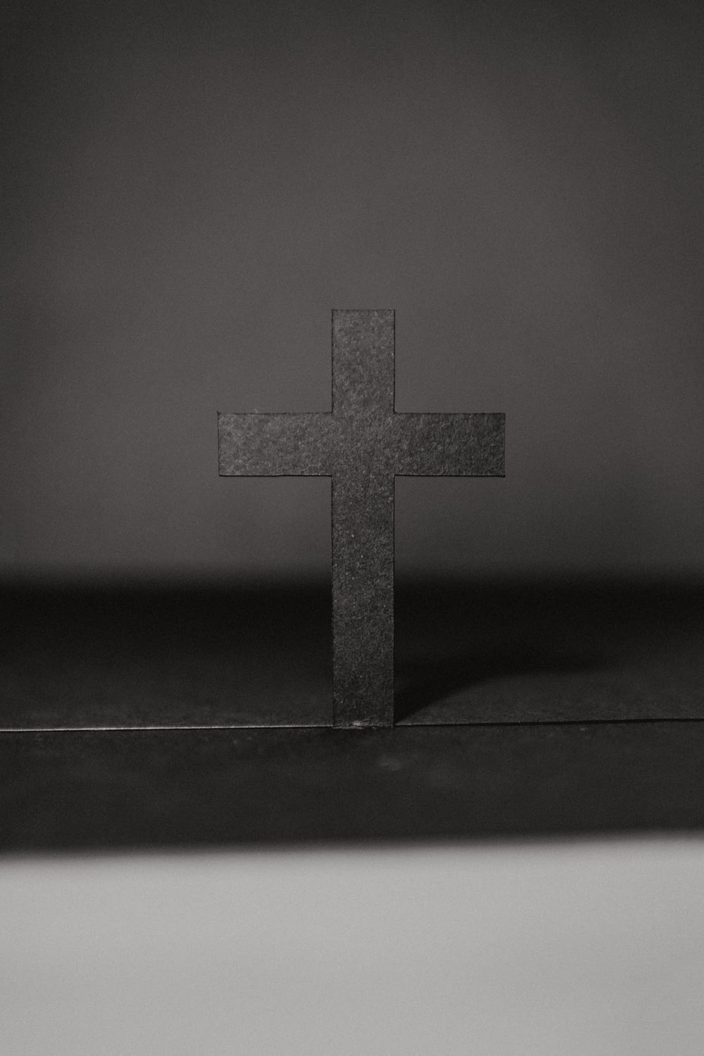 테이블에 십자가의 그레이스케일 사진