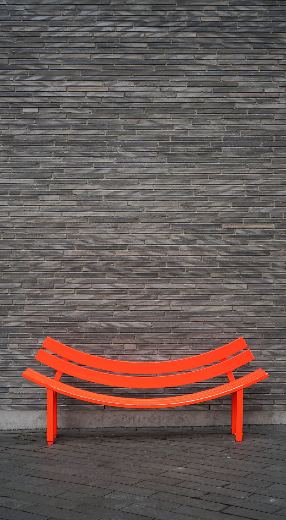 orange wooden bench on gray concrete floor