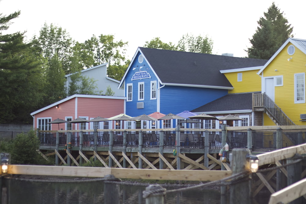 Maison en bois bleu et blanc près du plan d’eau pendant la journée