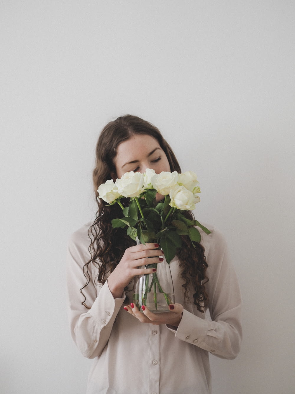 woman in white long sleeve shirt holding bouquet of white flowers
