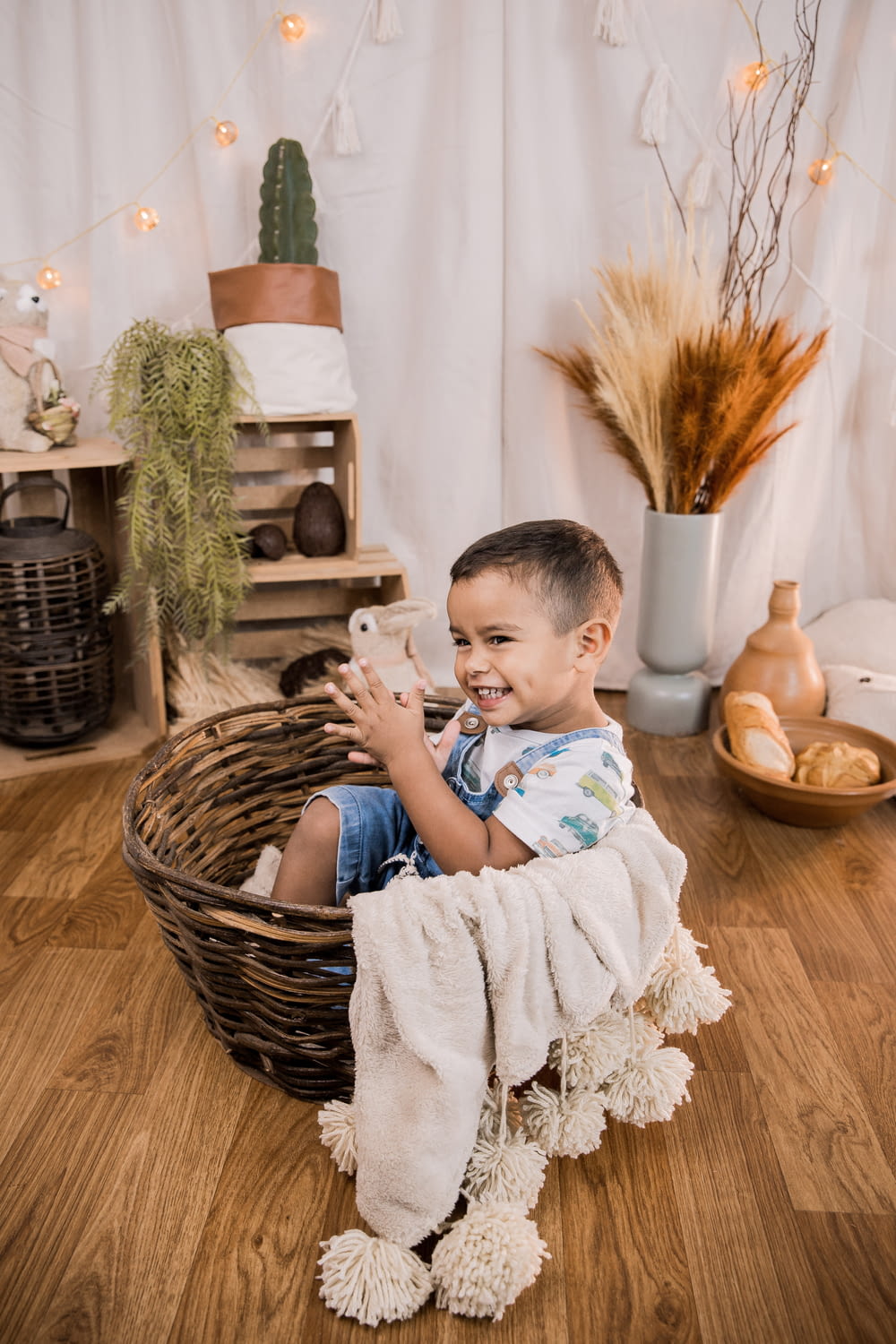 boy in blue and white stripe shirt sitting on brown woven basket