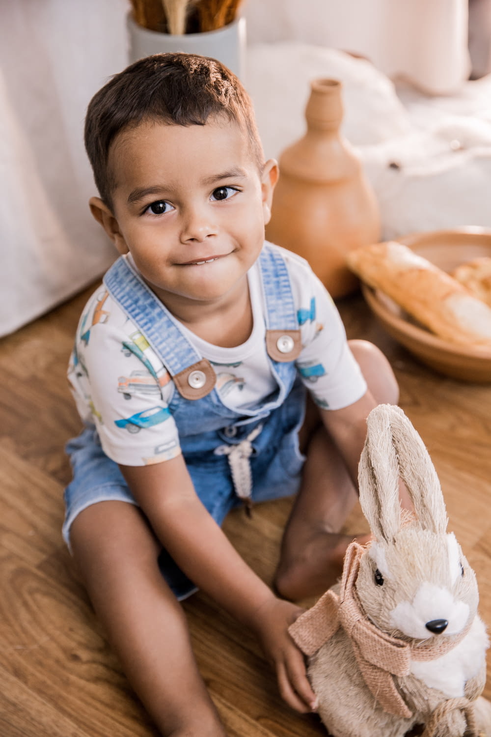 baby in blue and white onesie lying on brown wooden floor