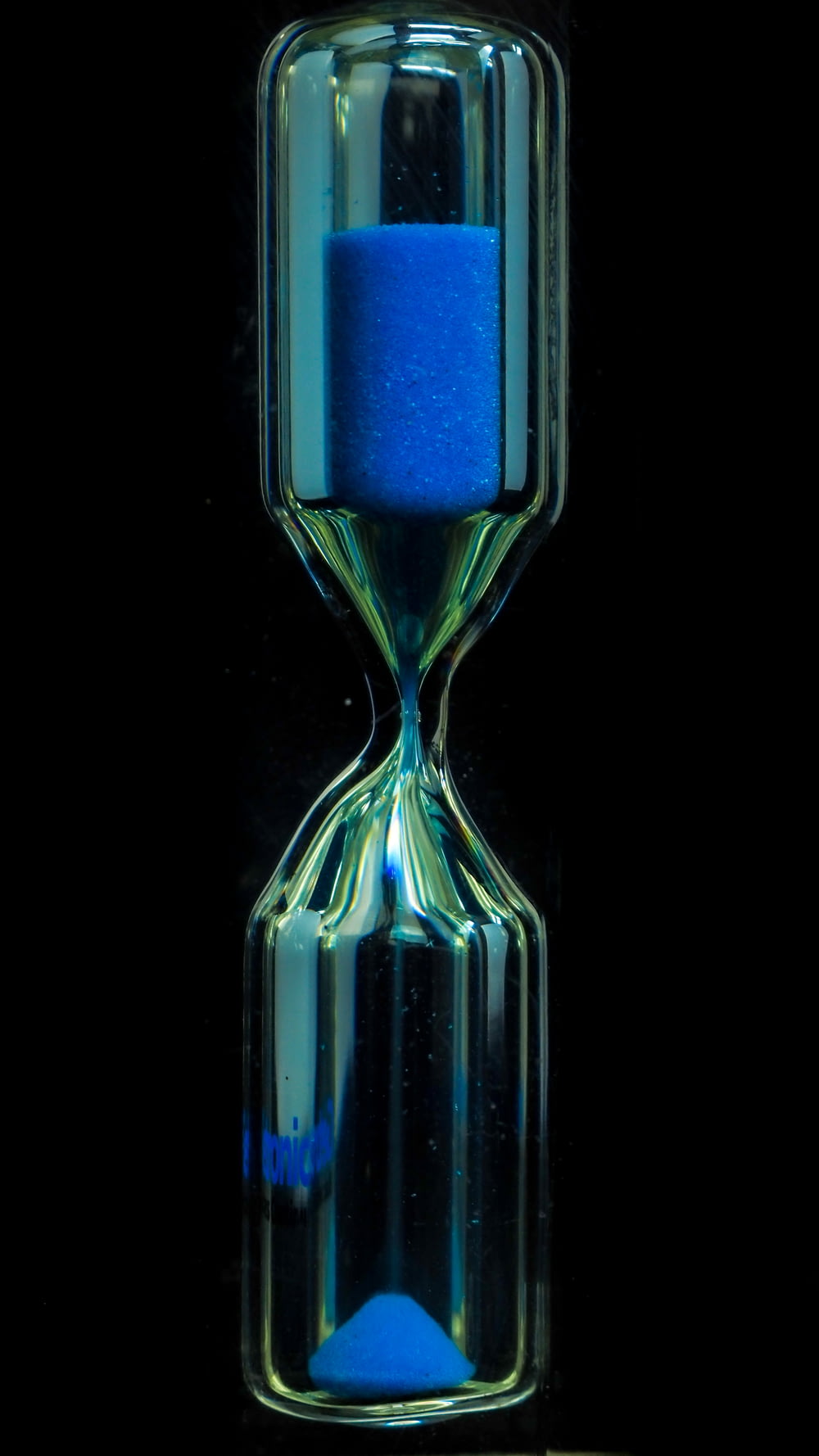 clear glass hour glass with blue liquid