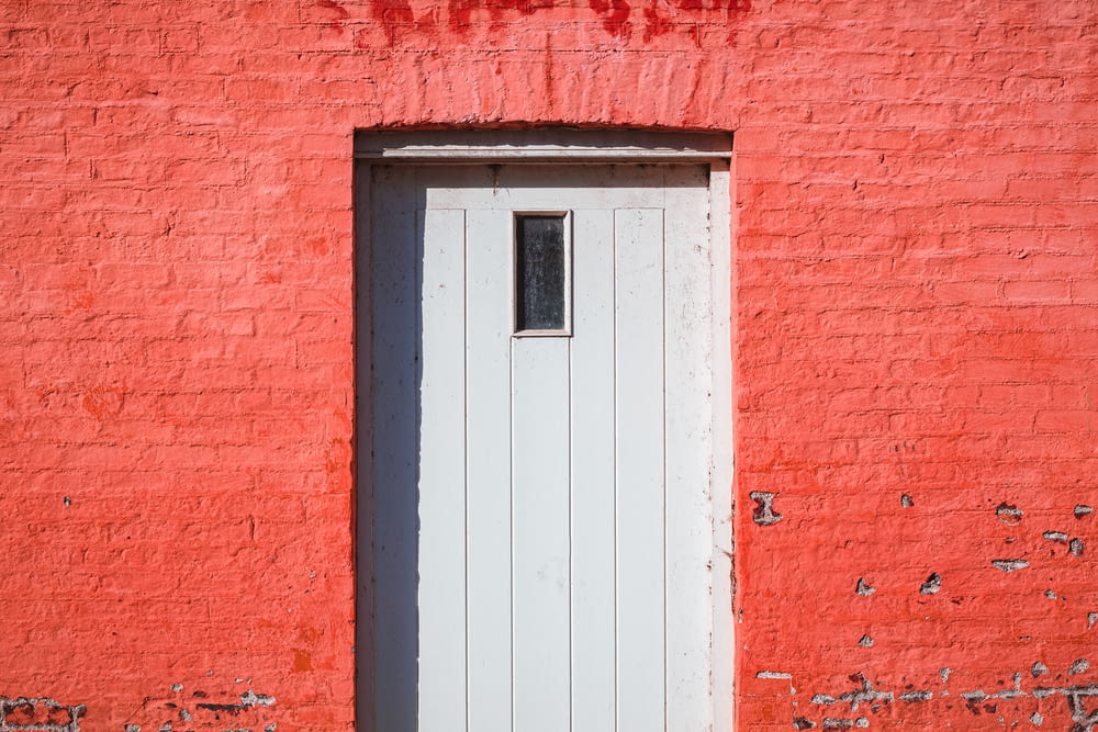 white wooden door on red brick wall