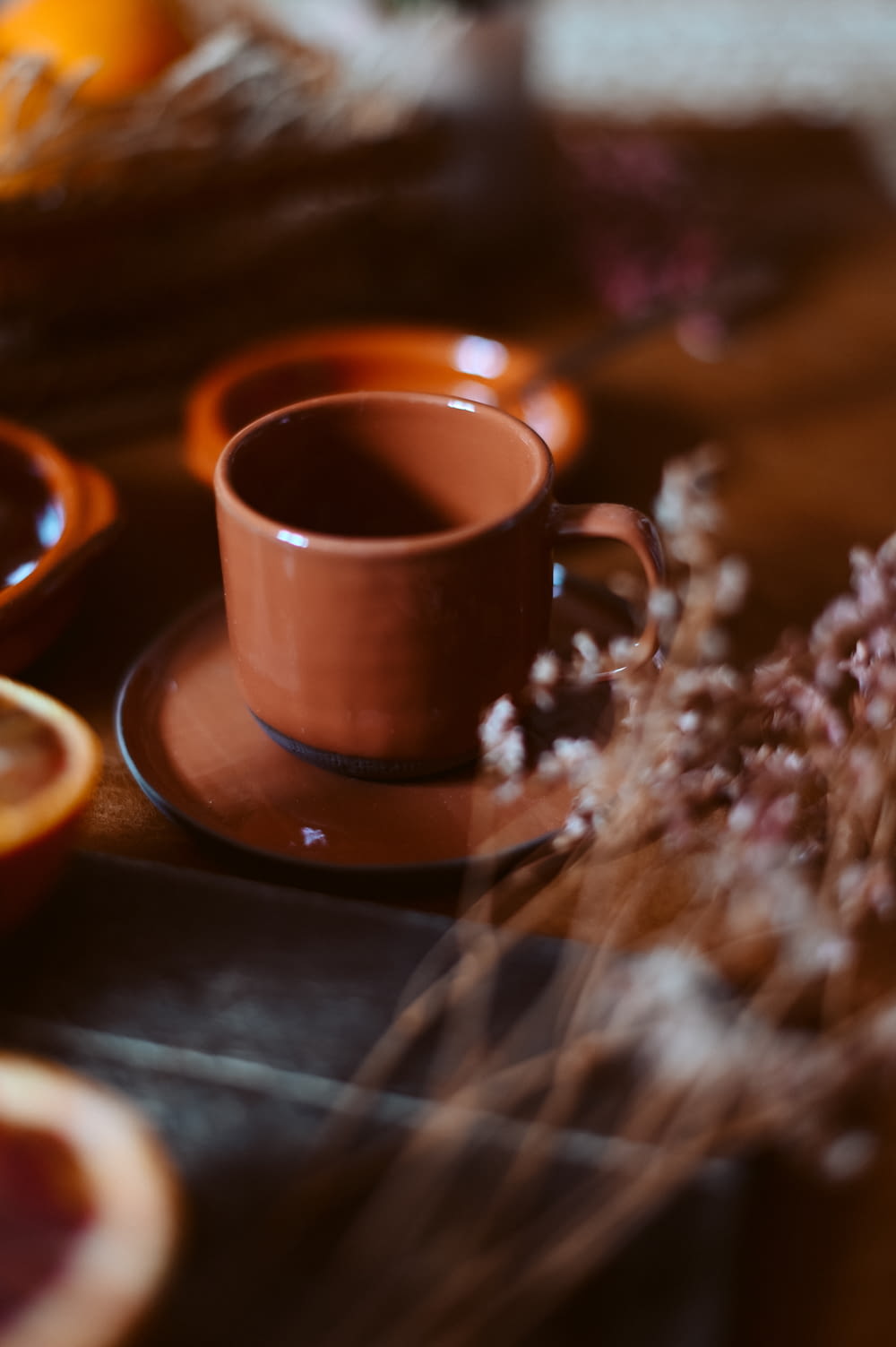 brown ceramic mug on brown saucer