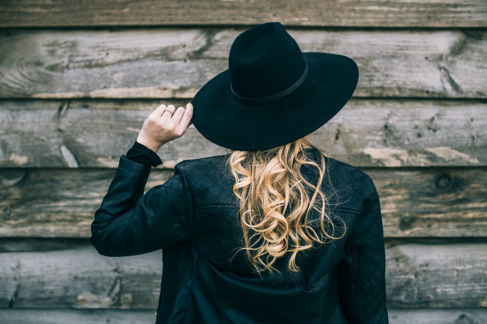 Frau in schwarzem Langarmhemd und schwarzem Hut