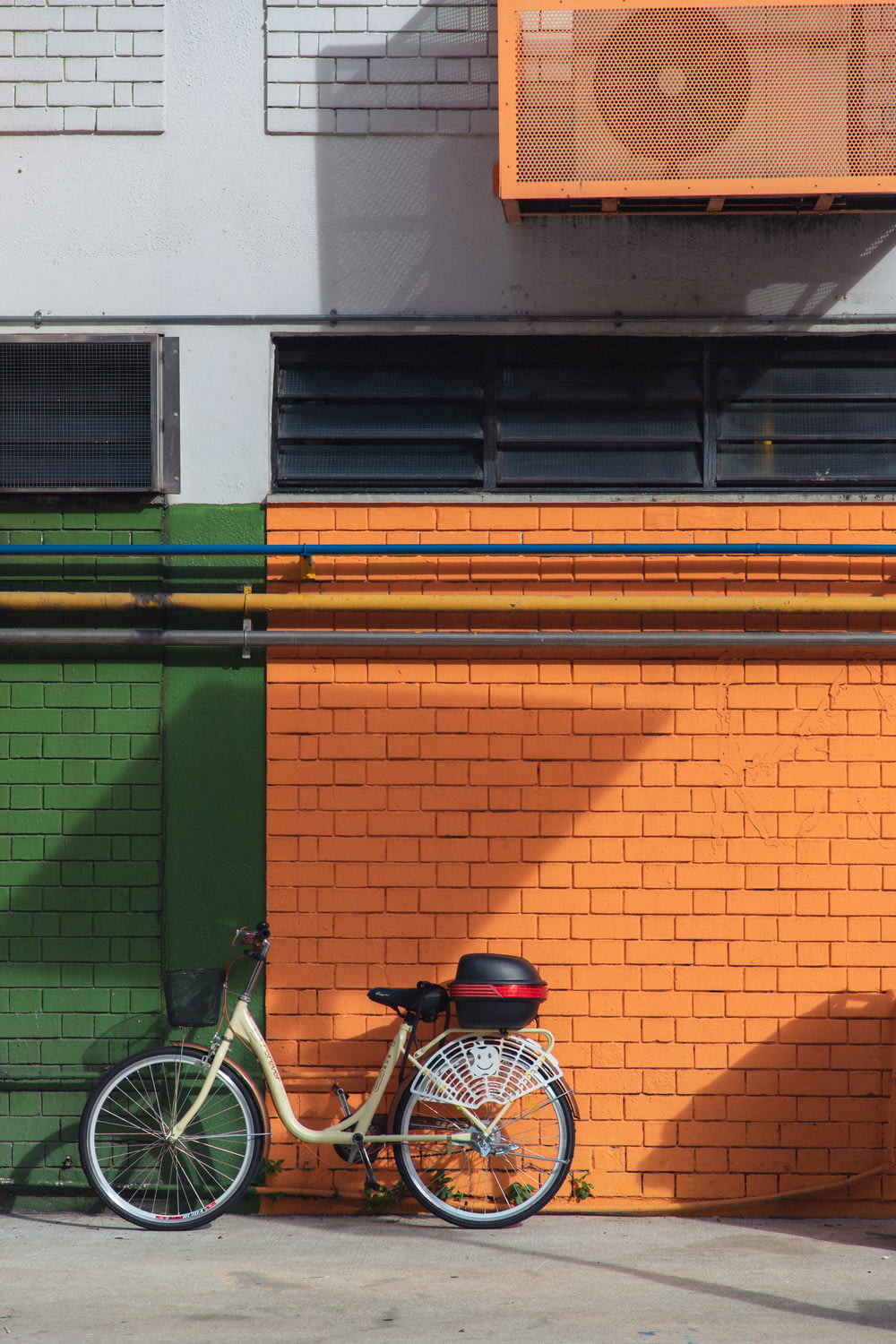 blue and white commuter bike parked beside green and brown concrete building