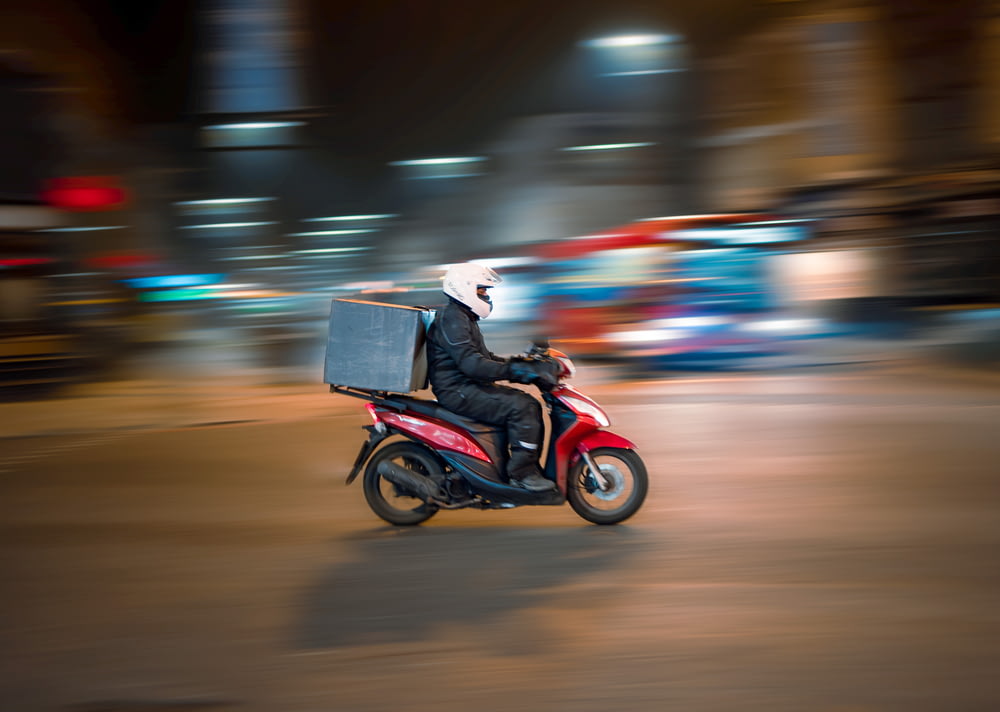 homme conduisant une moto sur la route pendant la journée
