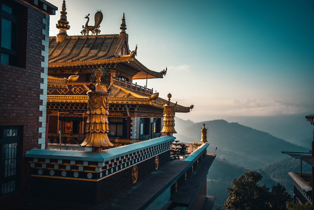 昼間の山の頂上にある茶色と緑の寺院