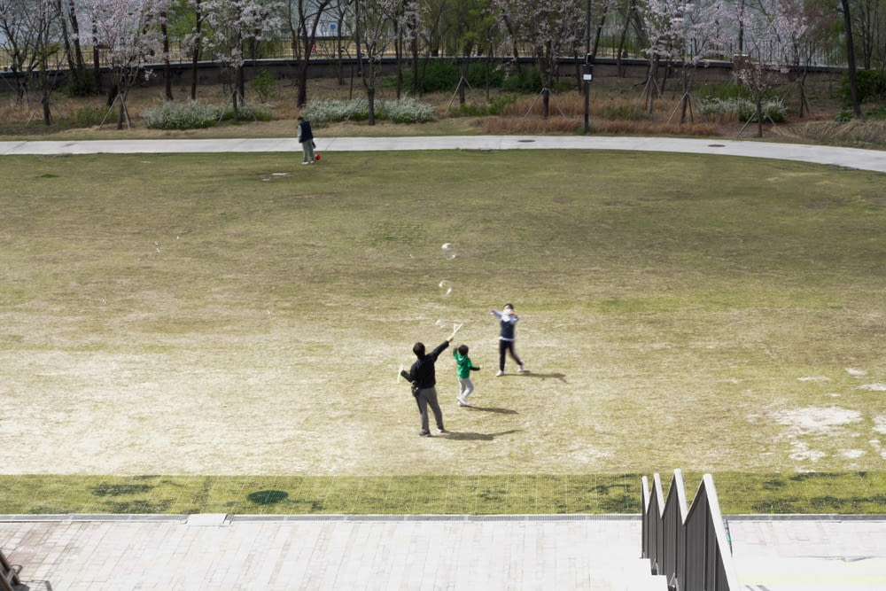 people playing basketball on field during daytime