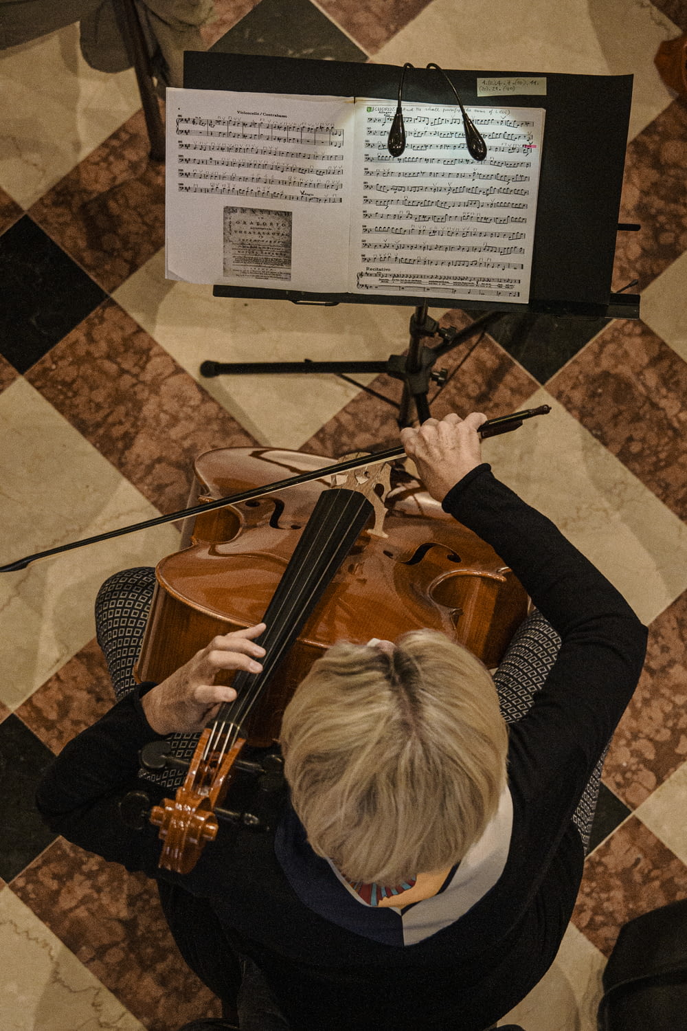 Persona che suona il violino sul pavimento marrone
