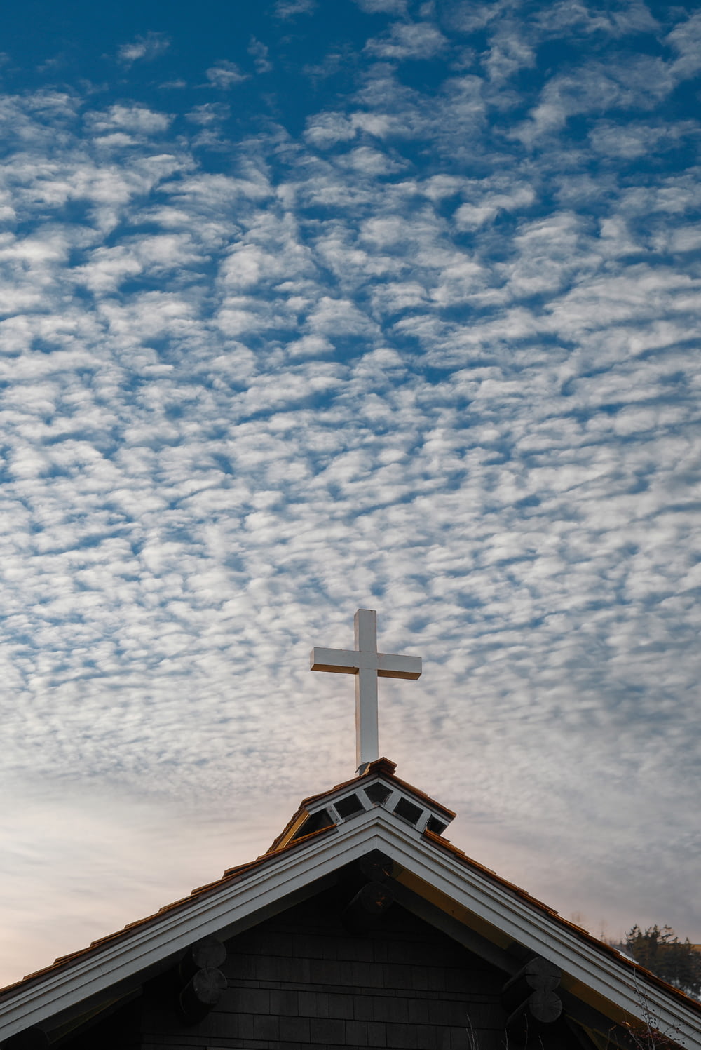 église brune et blanche sous ciel bleu et nuages blancs pendant la journée