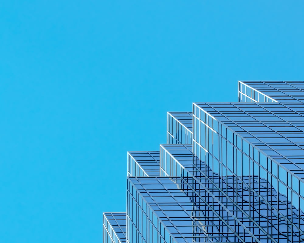 edifício de concreto branco e azul sob o céu azul durante o dia