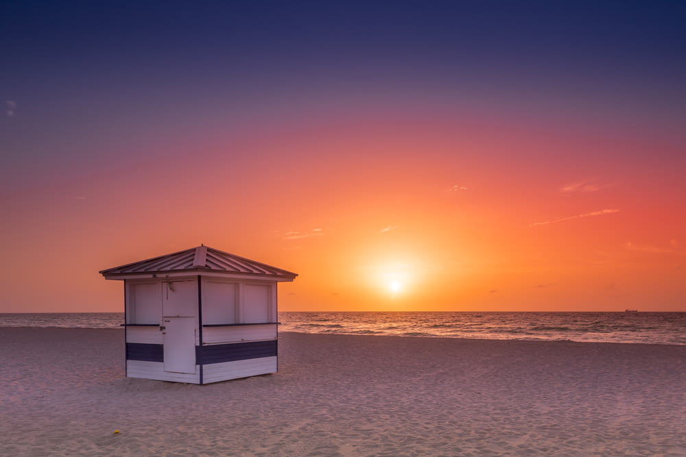 white wooden house on beach during sunset