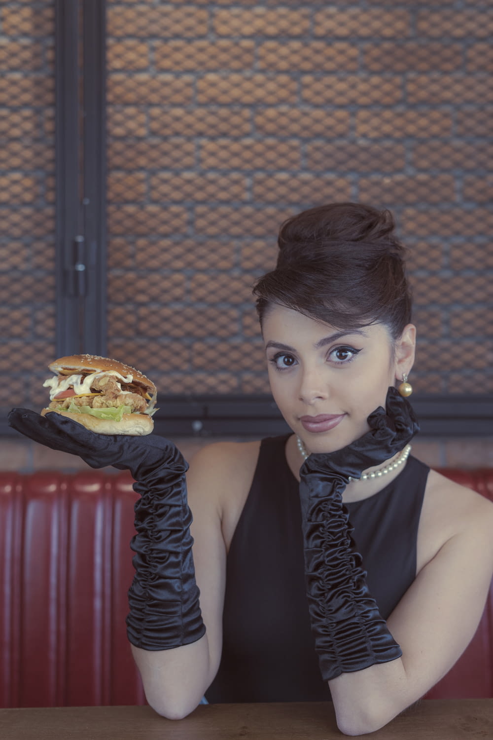 woman in black sleeveless top holding burger
