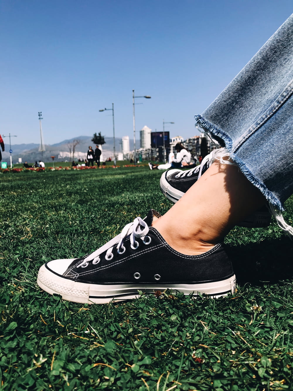 person in black and white converse all star high top sneakers