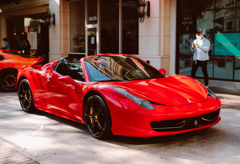 red ferrari 458 italia parked in front of store