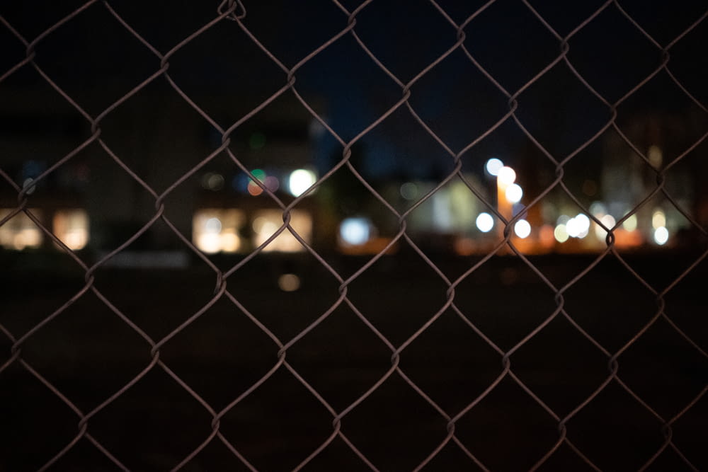 grey metal fence during night time