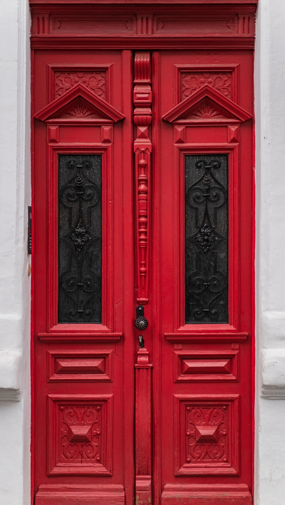 Puerta de madera roja con palanca de puerta de acero negro