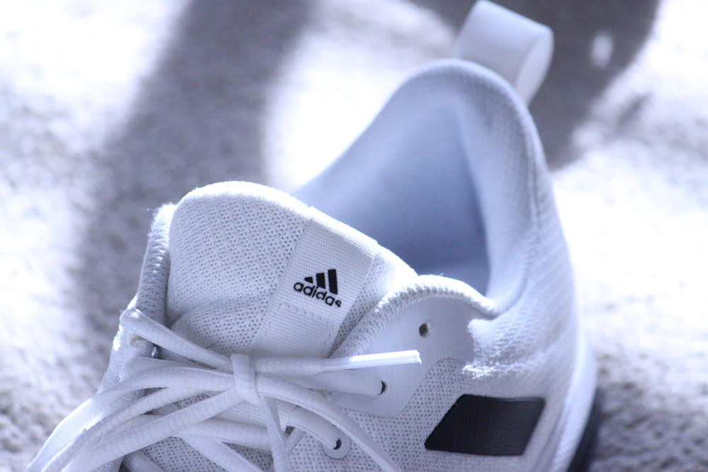 white adidas low top sneakers