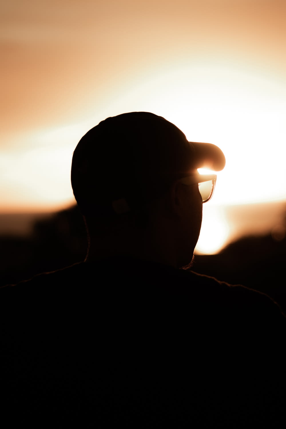 Silhouette eines Mannes mit Sonnenbrille während des Sonnenuntergangs