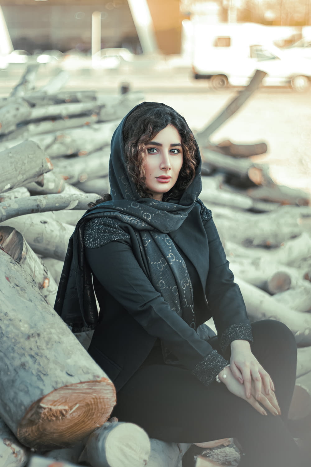 woman in black hijab sitting on rock during daytime