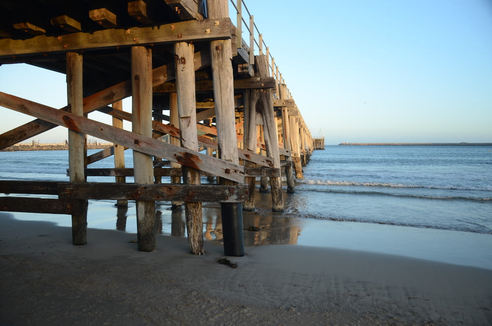 Muelle de madera marrón en la playa durante el día