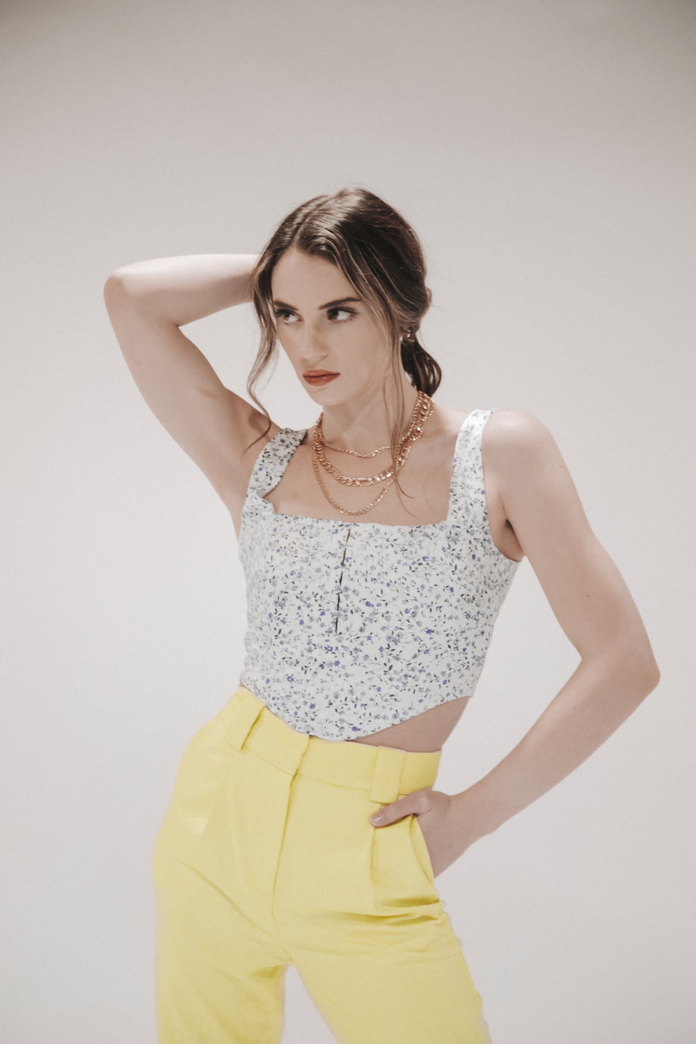 woman in white and yellow floral tank top and yellow skirt