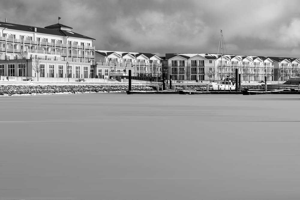 Foto en escala de grises de un edificio cerca de un cuerpo de agua