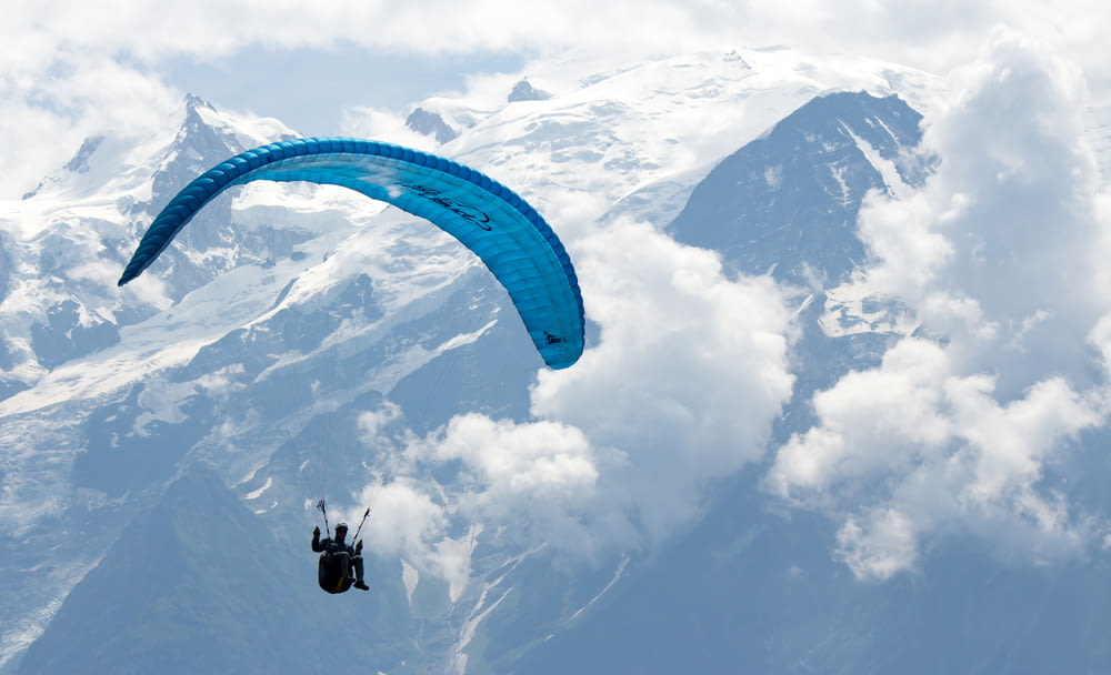 person in black and white parachute over snow covered mountain during daytime