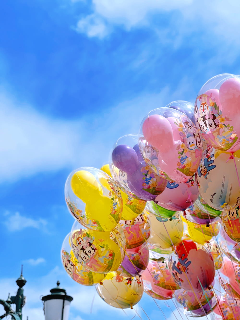 yellow red and blue balloons under blue sky during daytime