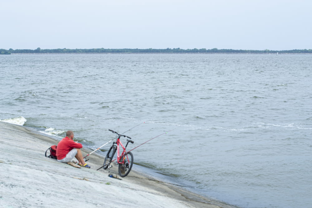 man and woman riding bicycle on beach during daytime