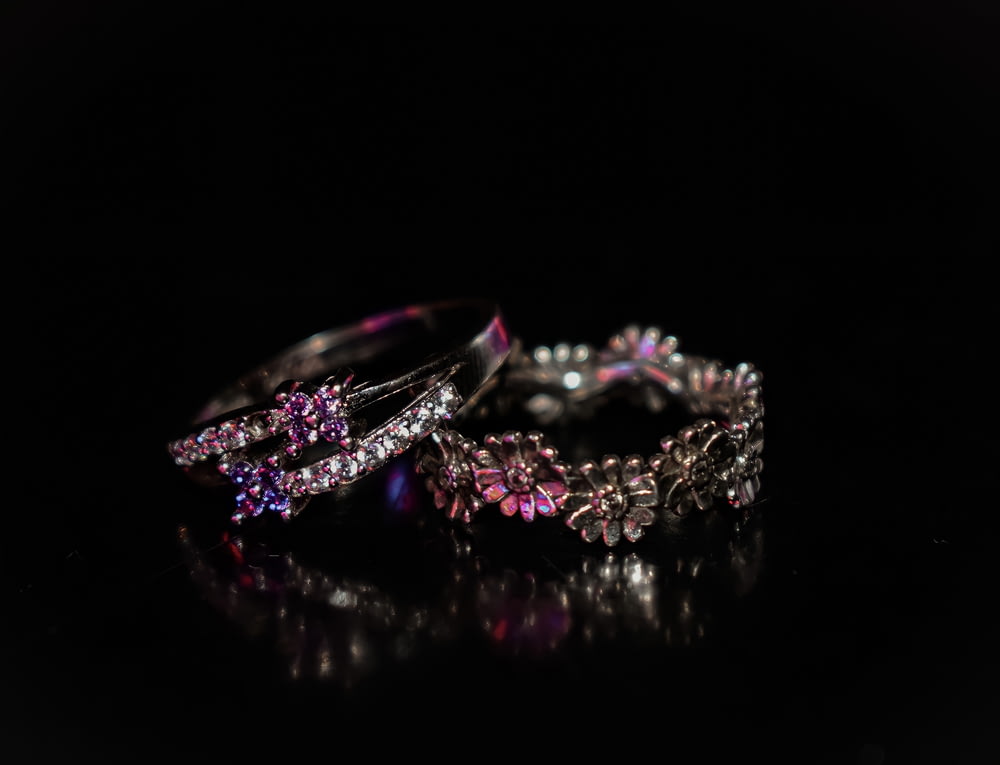 silver diamond studded ring on black background