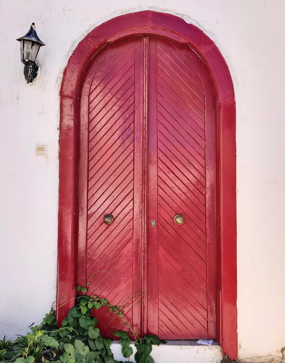 red wooden door with black steel door lever