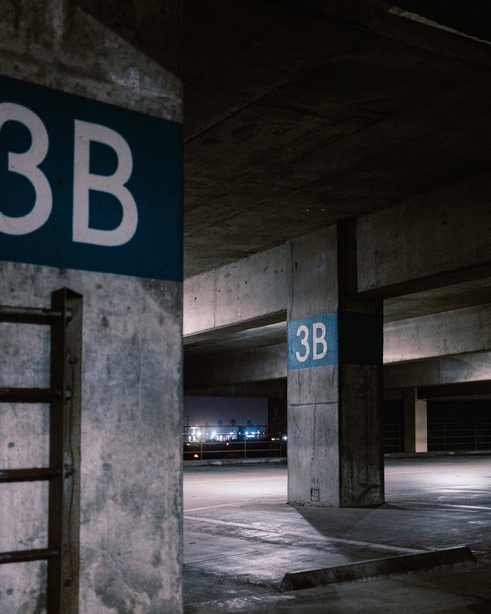 an empty parking garage with a blue and white sign